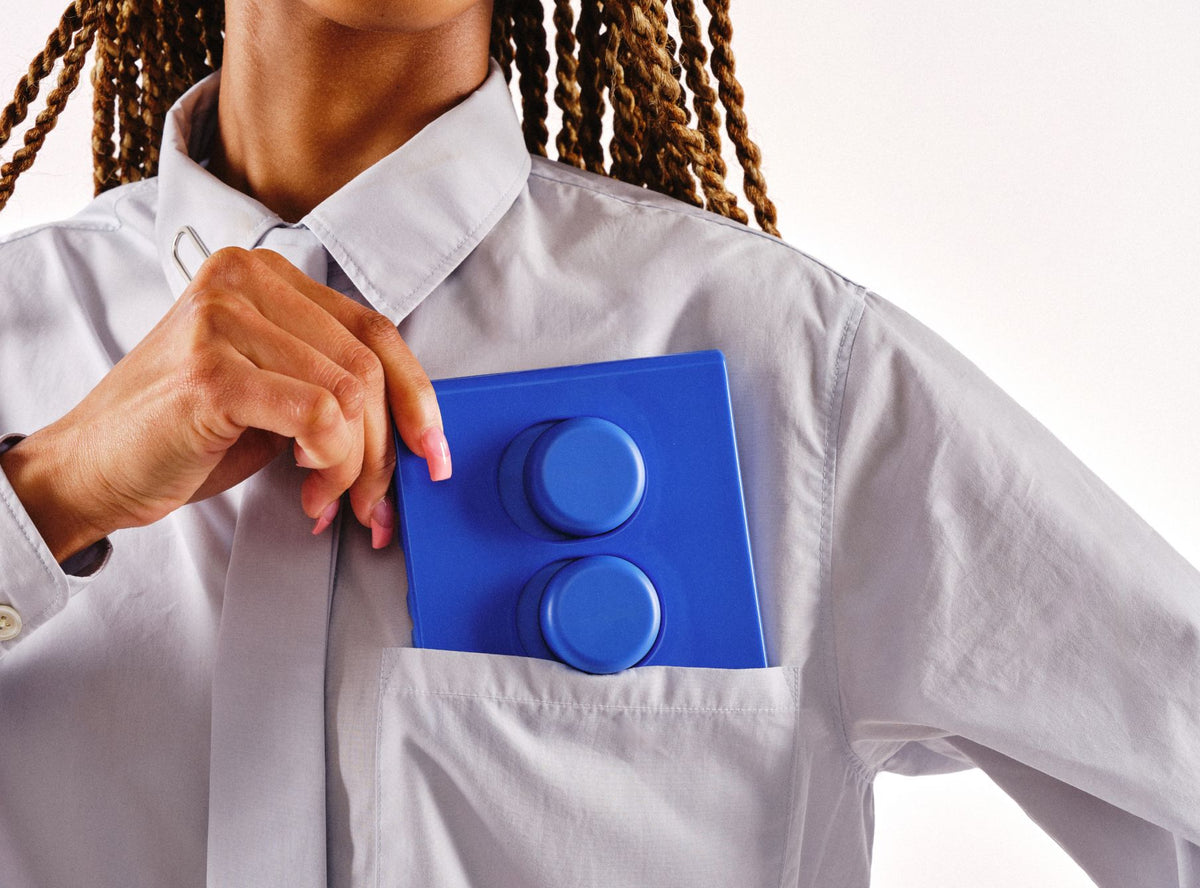 Model pulling a blue Switch T-2 double toggle from a shirt pocket