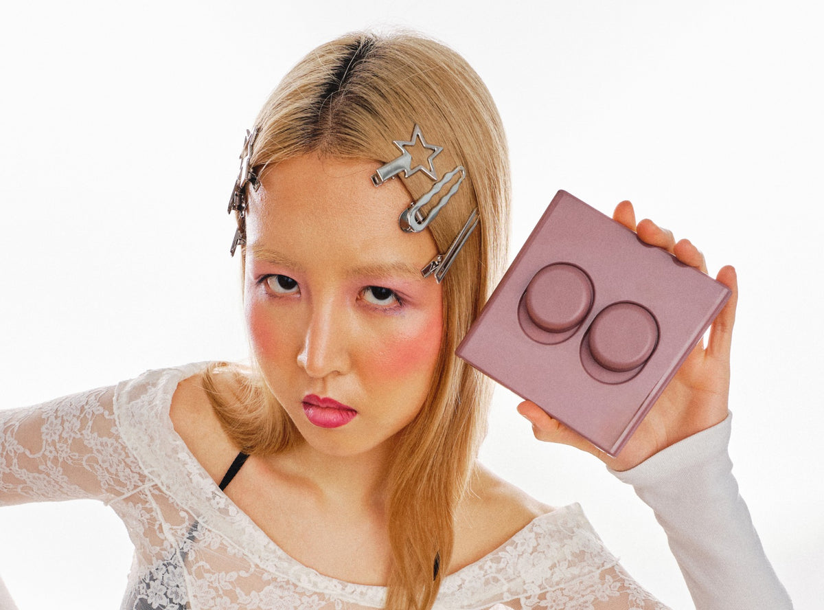 Model with star hair clips holding a pink Switch T-2 double toggle beside their face